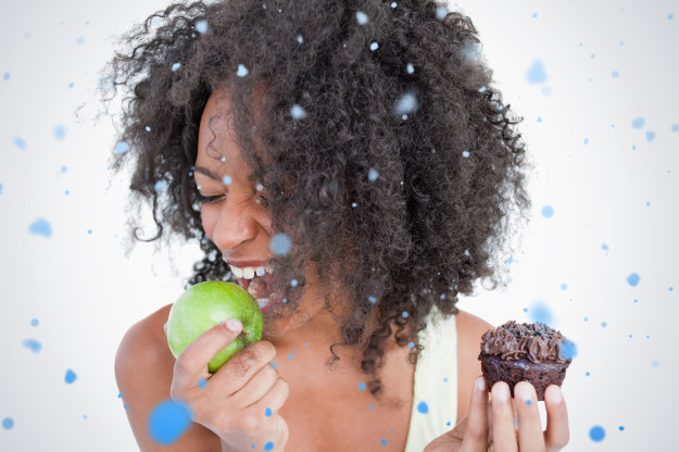 Young woman going to eat a delicious green apple against snow fa